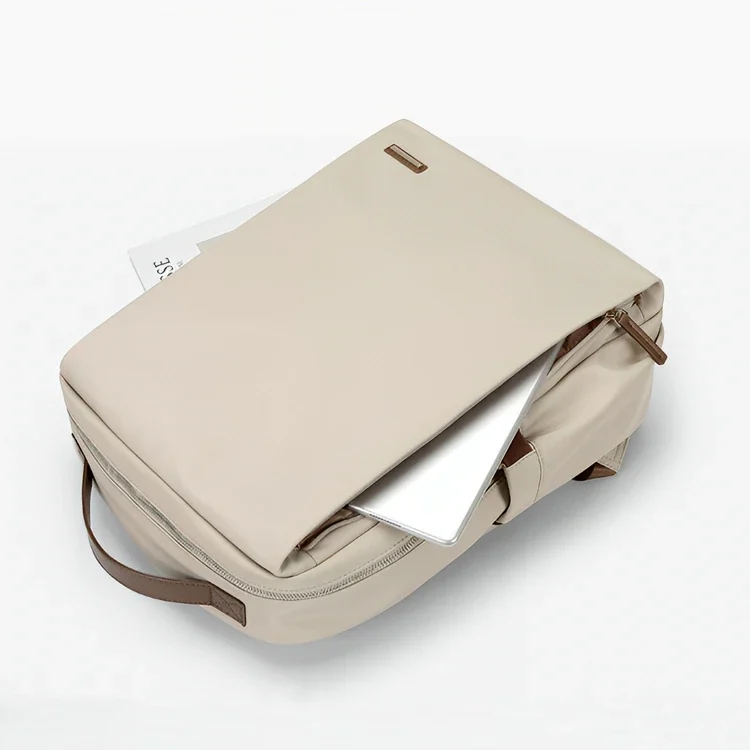ベージュカラーのビジネスリュックに15.6インチのノートパソコンと書類が収納されている様子