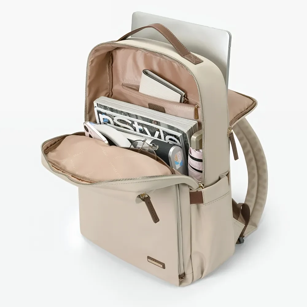 ベージュ色のビジネスリュックが開いた状態でノートパソコンや雑誌、手帳、スマートフォンなどが収納されている様子