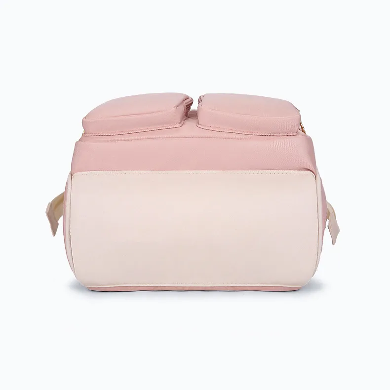 ピンクの本体とベージュの底面が特徴的な、マザーズリュックを下から見た様子。