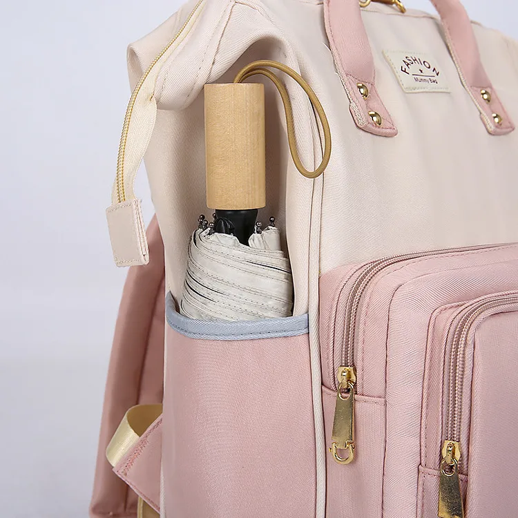 クリーム色とピンクのバッグ側面のポケットと、上品なゴールドのファスナーの拡大写真