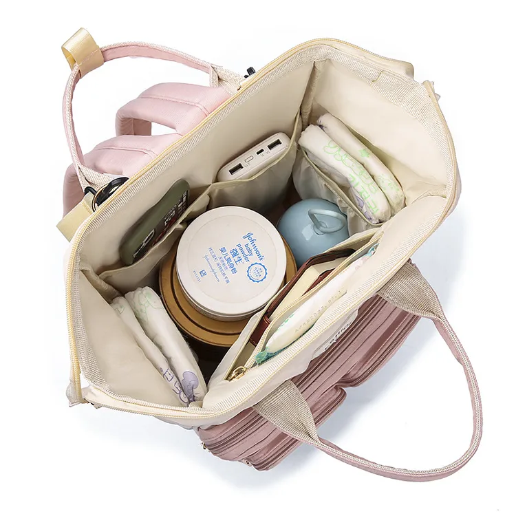 マザーズバッグの内側を上から見た様子です。明るいクリーム色の裏地と、小物を整理しやすいゴム付きポケットが配置されています。