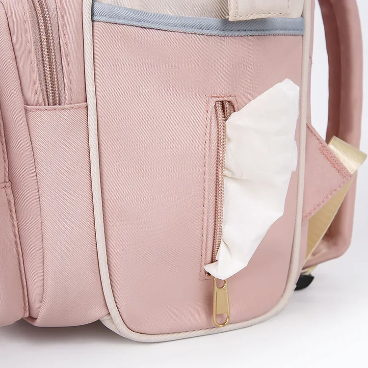 ピンク色のマザーズバッグの側面にある、おしりふきを片手でサッと取り出せるファスナー付きポケットのクローズアップ